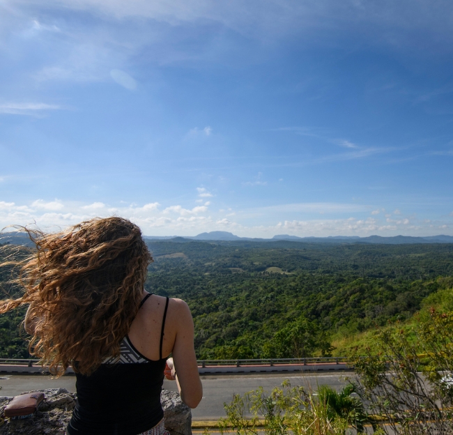 A student gazes out over a Cuban forest