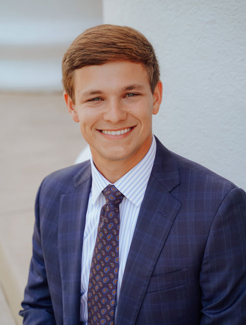 Anderson DeWitt smiling wearing a suit. 