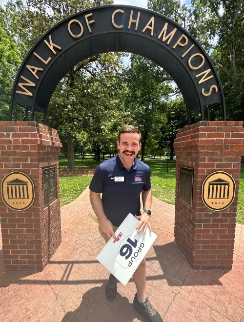 Brady Wood standing underneath the Walk of Champions arch