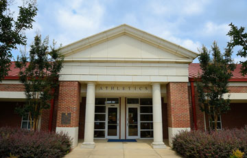 Exterior of the Athletics Administration Building. Building has white stone exterior with "athletics" written across the top of the building.