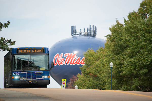 An OUT bus comes over a hill on campus