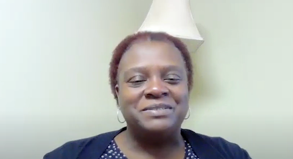 woman with short hair smiling in front of lamp