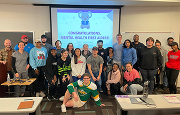 group of student housing staff in front of PowerPoint screen