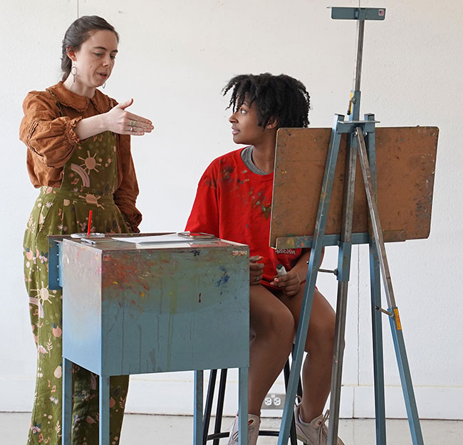 Student painting with an instructor