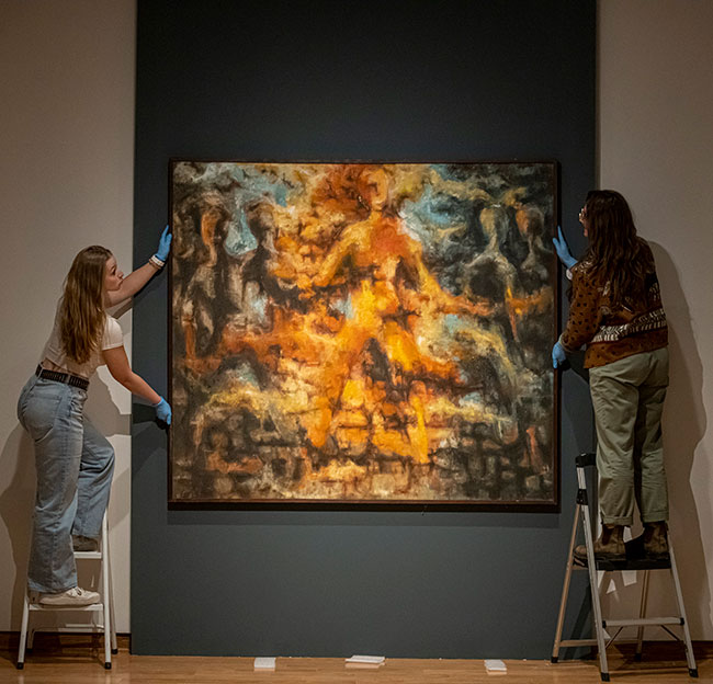 students hanging a paint at um museum