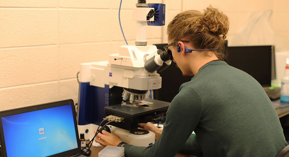 Student using the A Zeiss Axio Imager M1 microscope.