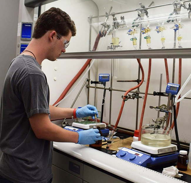 high school male student working in a biology lab area