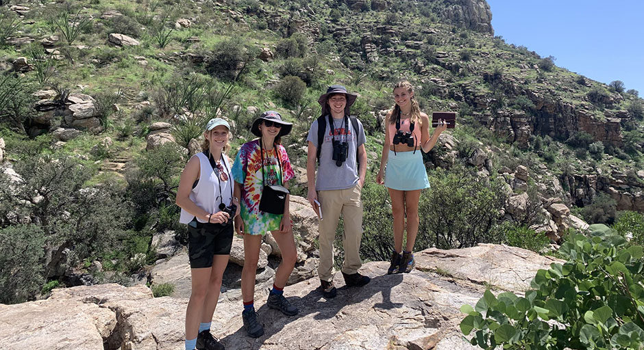 students standing and smiling for a photo in the desert