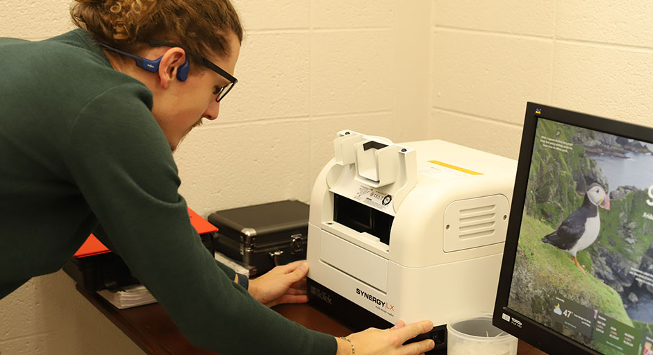 student using the Biotek Synergy LX Multi-Mode Plate Reader