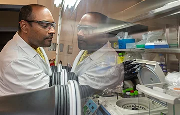 man turned to the left working in lab