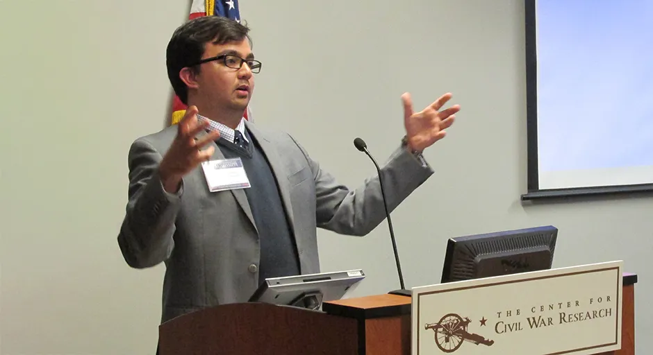 Man at podium with arms outstretched