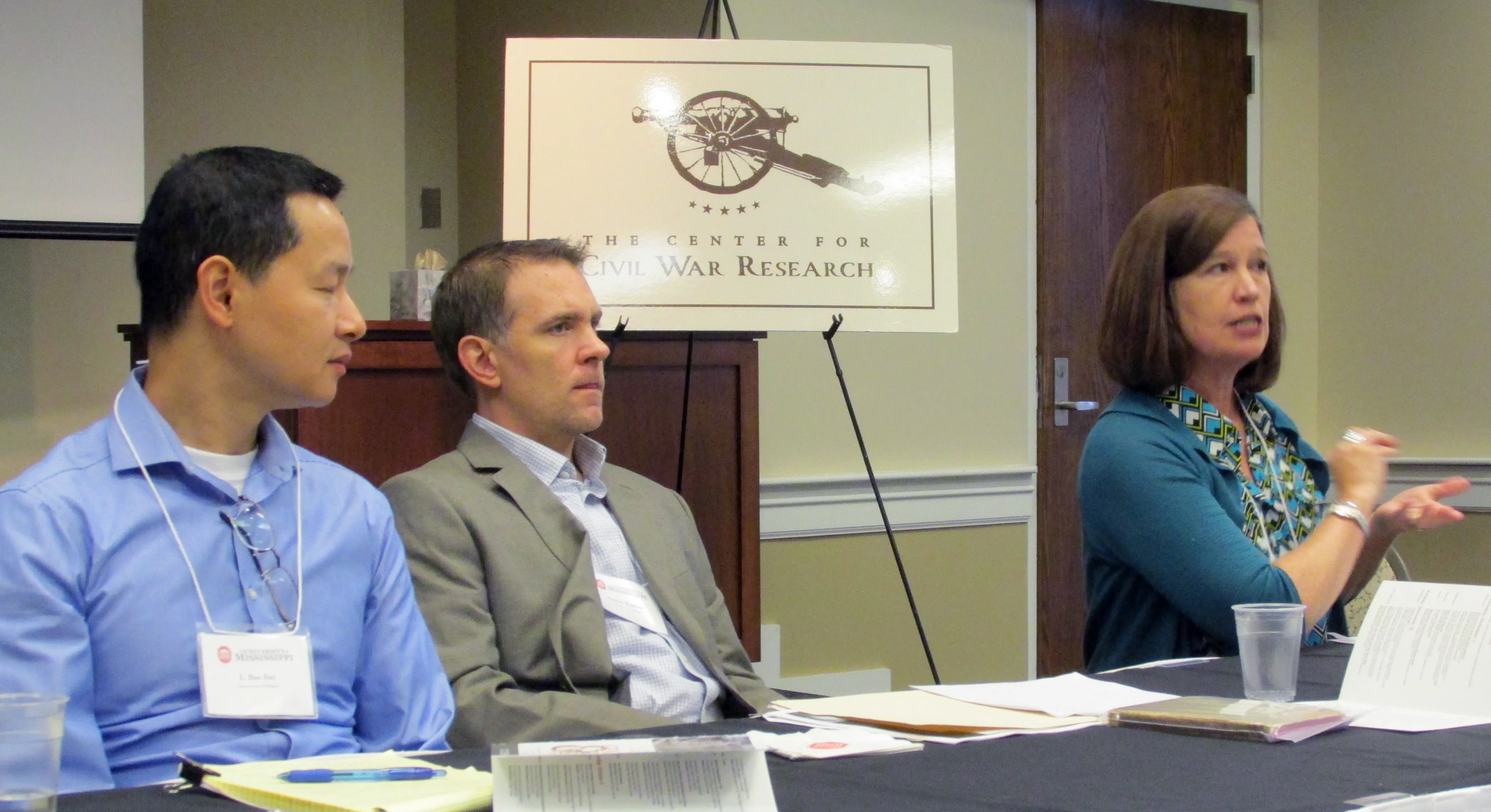 Three people sitting at a table with sign behind them reading: "The Center for Civil War Research"