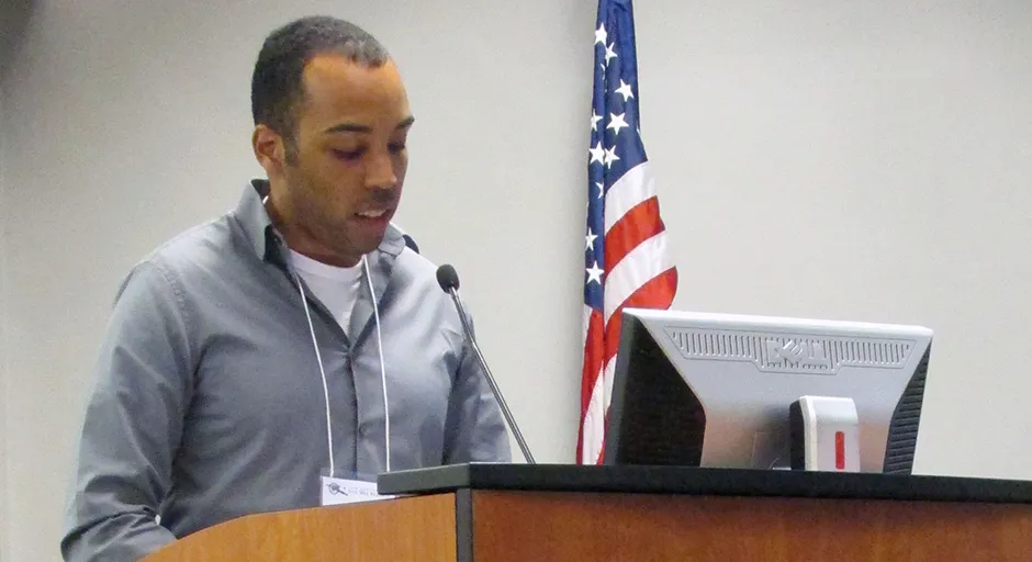 a man stands behind a podium and reads from a paper