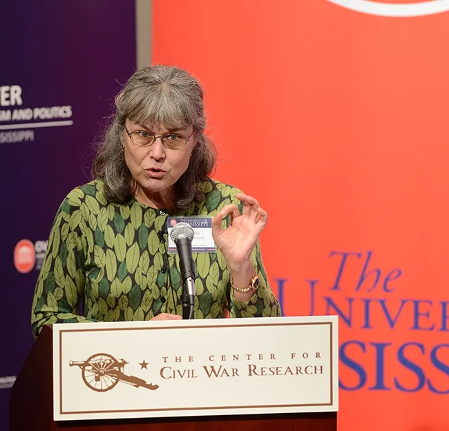 Woman behind podium giving lecture. Sign on podium reads "The Center for Civil War Research"