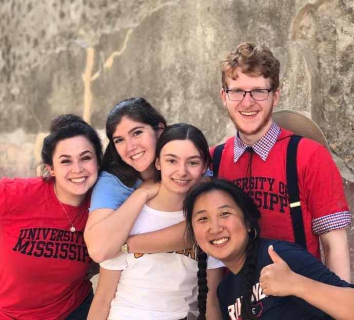 image of a small group of students smiling at the camera at an ancient Italian site.