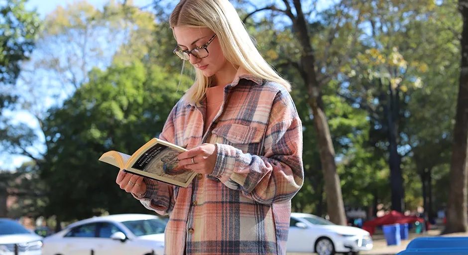 Woman looks down at opened book