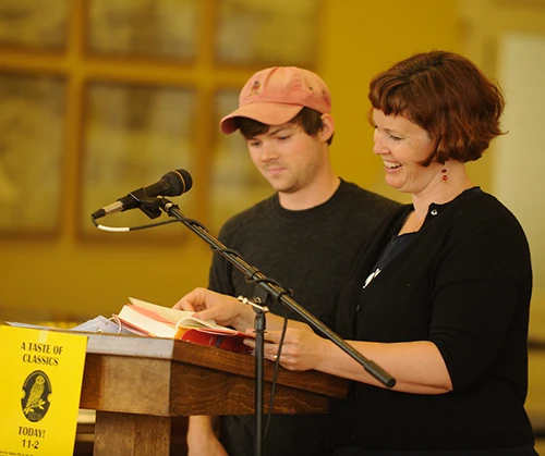 Professor and student at a podium. Sign in front of podium reads: A Taste of Classics