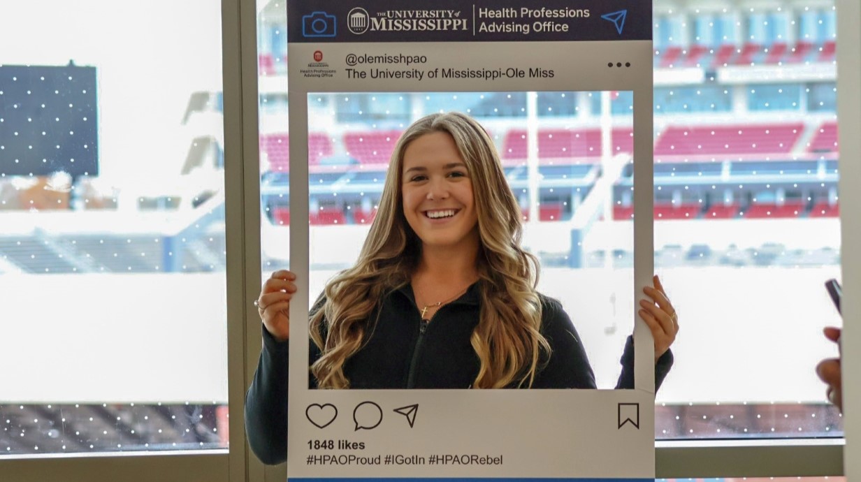 student holding up an instagram frame to celebrate her admission to dental school