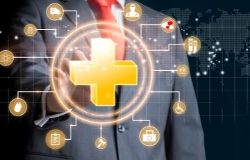 image of a man in a business suite with health care icons in front of him as he reaches to click on a medical cross symbol