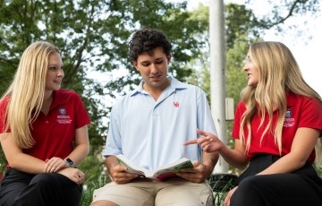 three students seated and talking together in the Circle