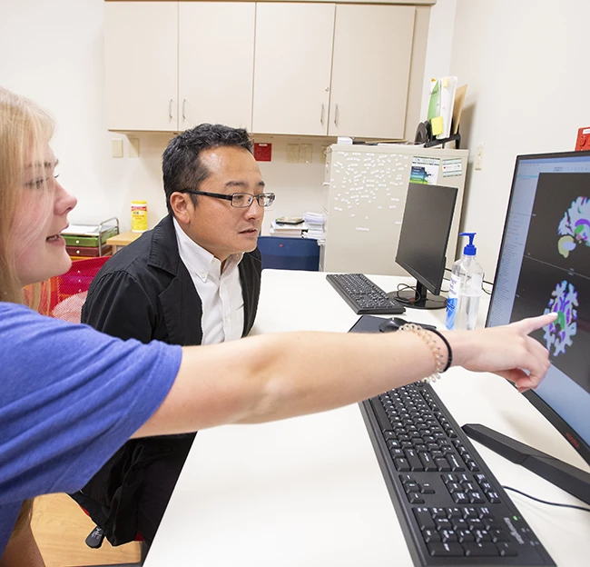 Nikki Jones reviews sample work with Dr. Toshikazu Ikuta in his digital neuroscience lab at the South Oxford Center.