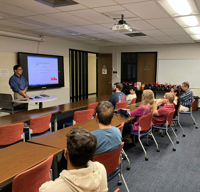 professor standing in front of a group of students and gives a presentation