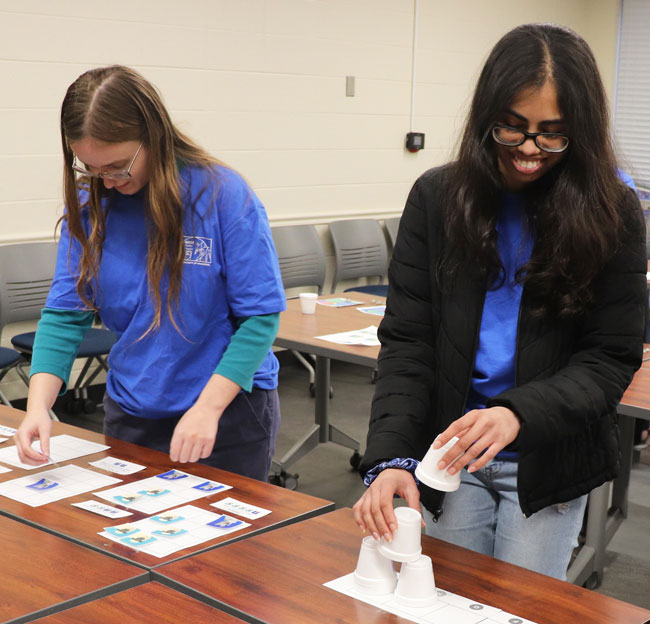 two female students working with materials on a table