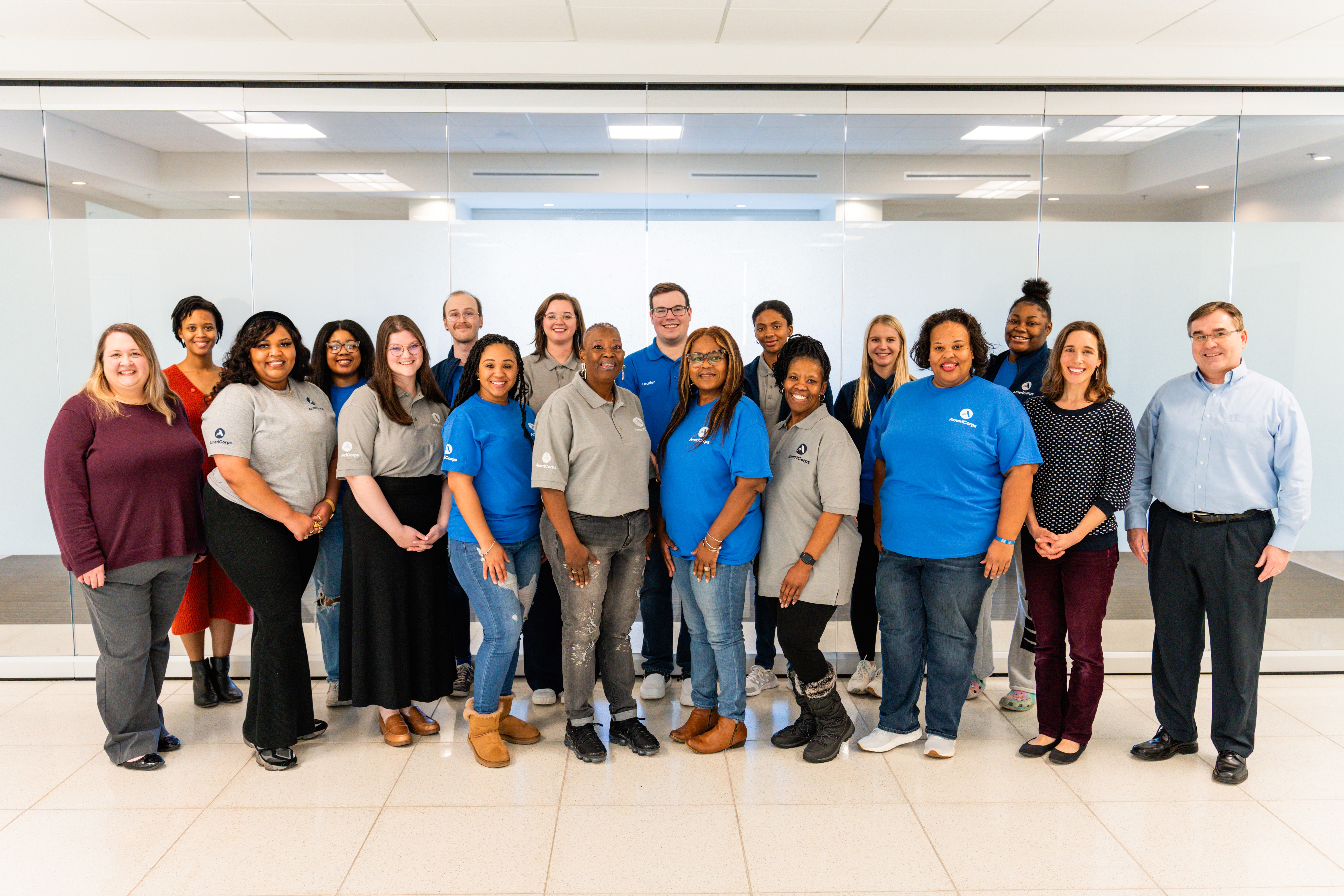 Members of the North Mississippi VISTA Project and Staff pose in front of a clear glass wall