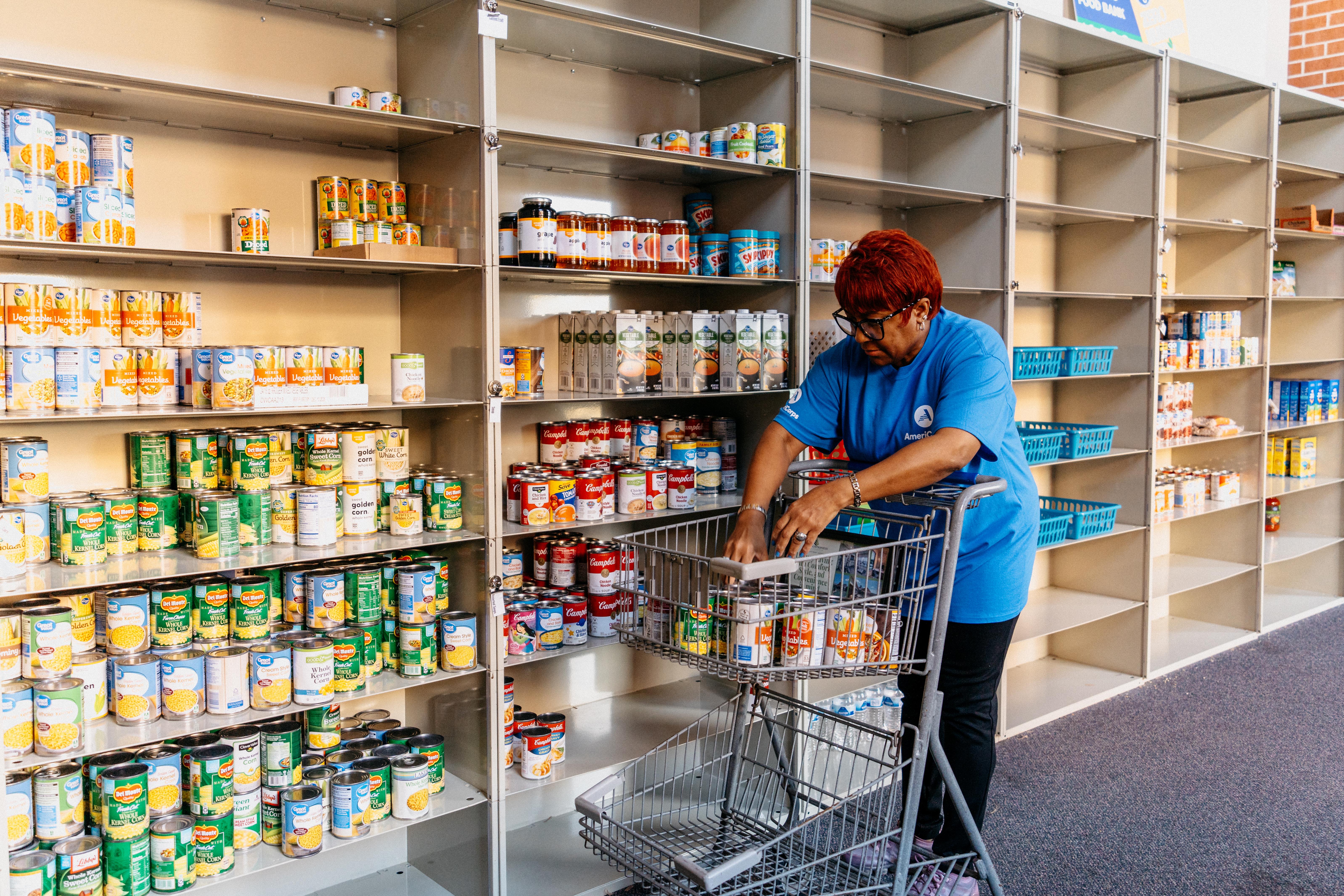 An AmeriCorps member sorts food at a food pantry.