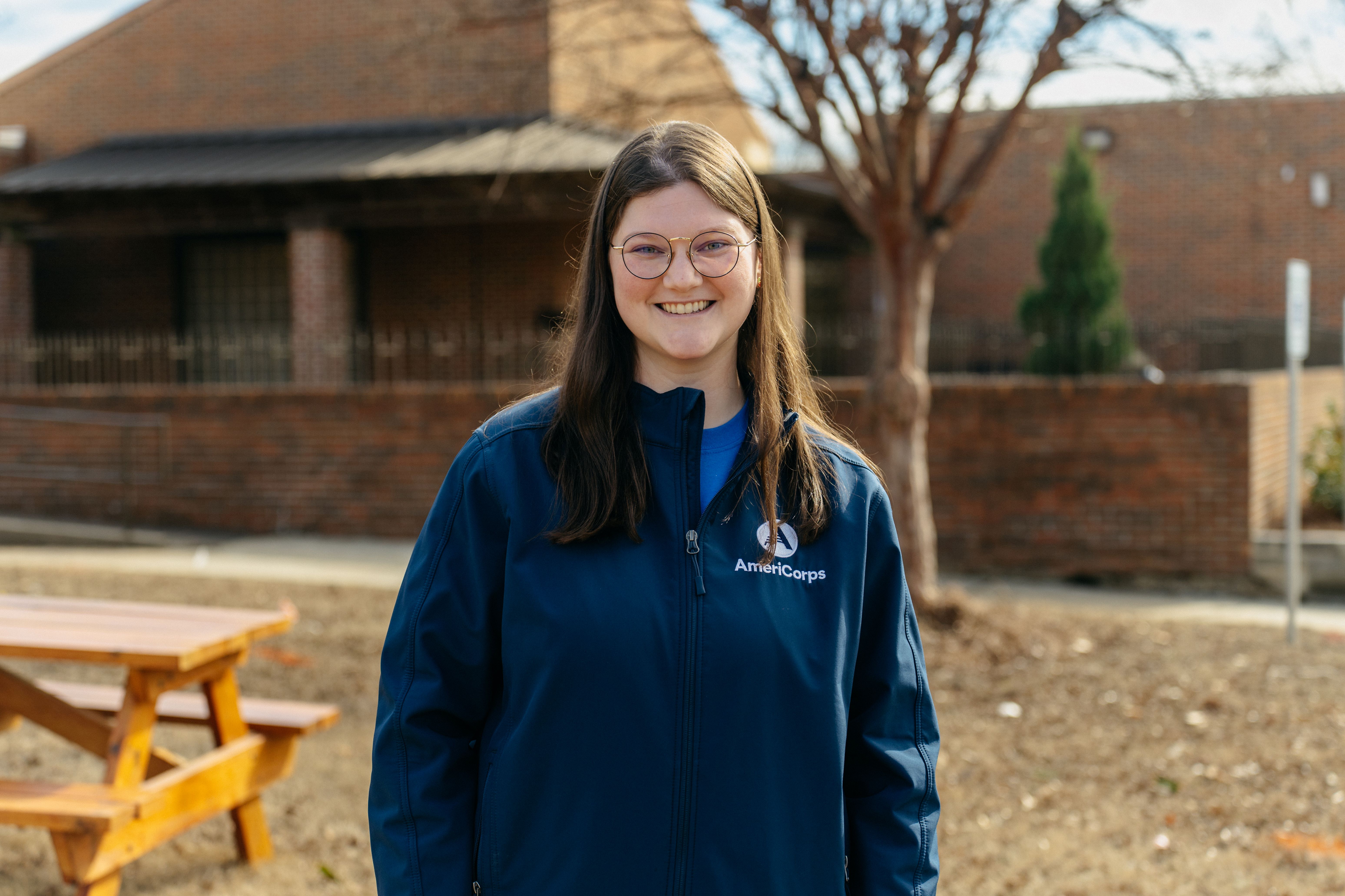 AmeriCorps member, Elizabeth, poses in front of the Oxford Housing Authority