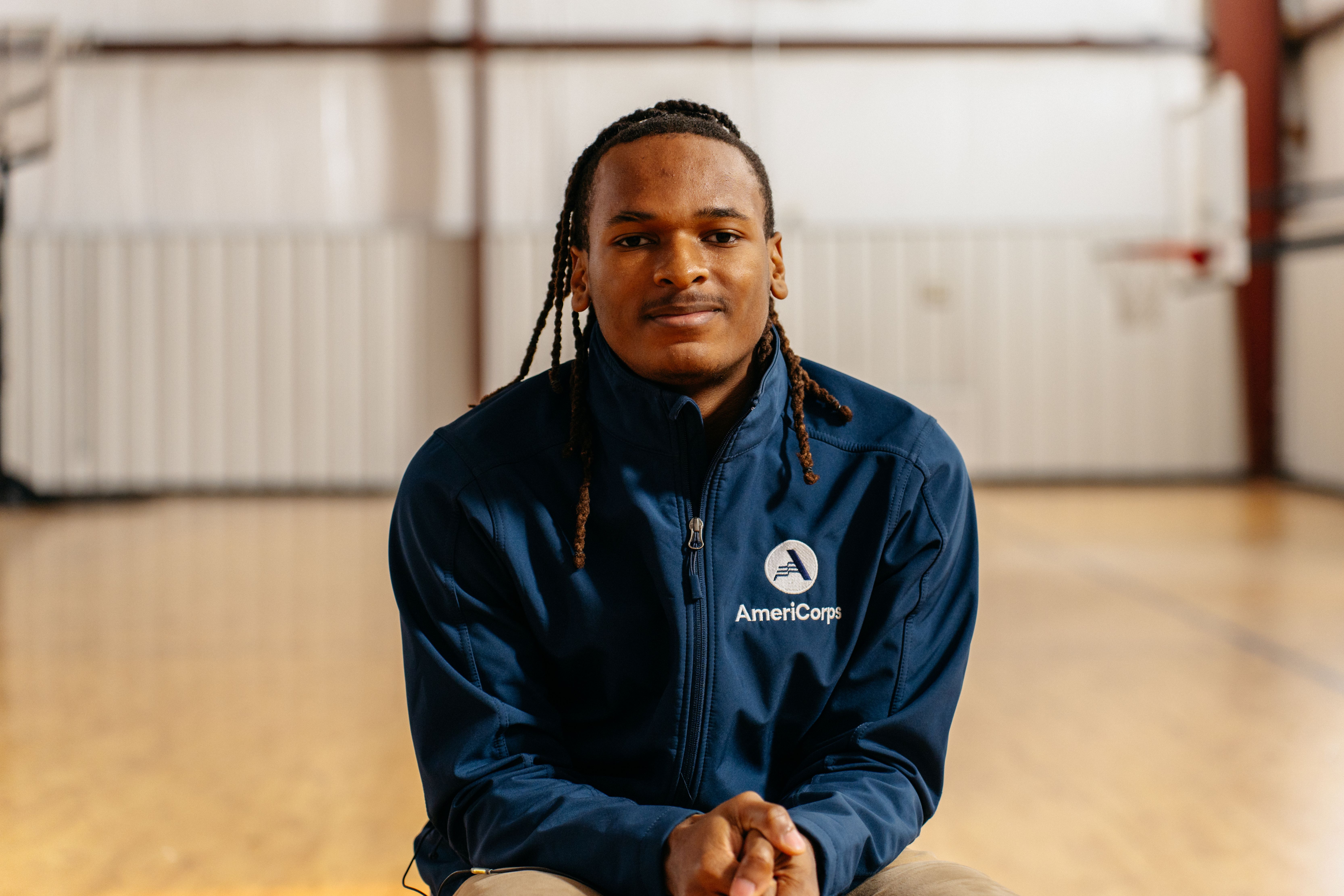 AmeriCorps member, Trayveon, poses in a gym