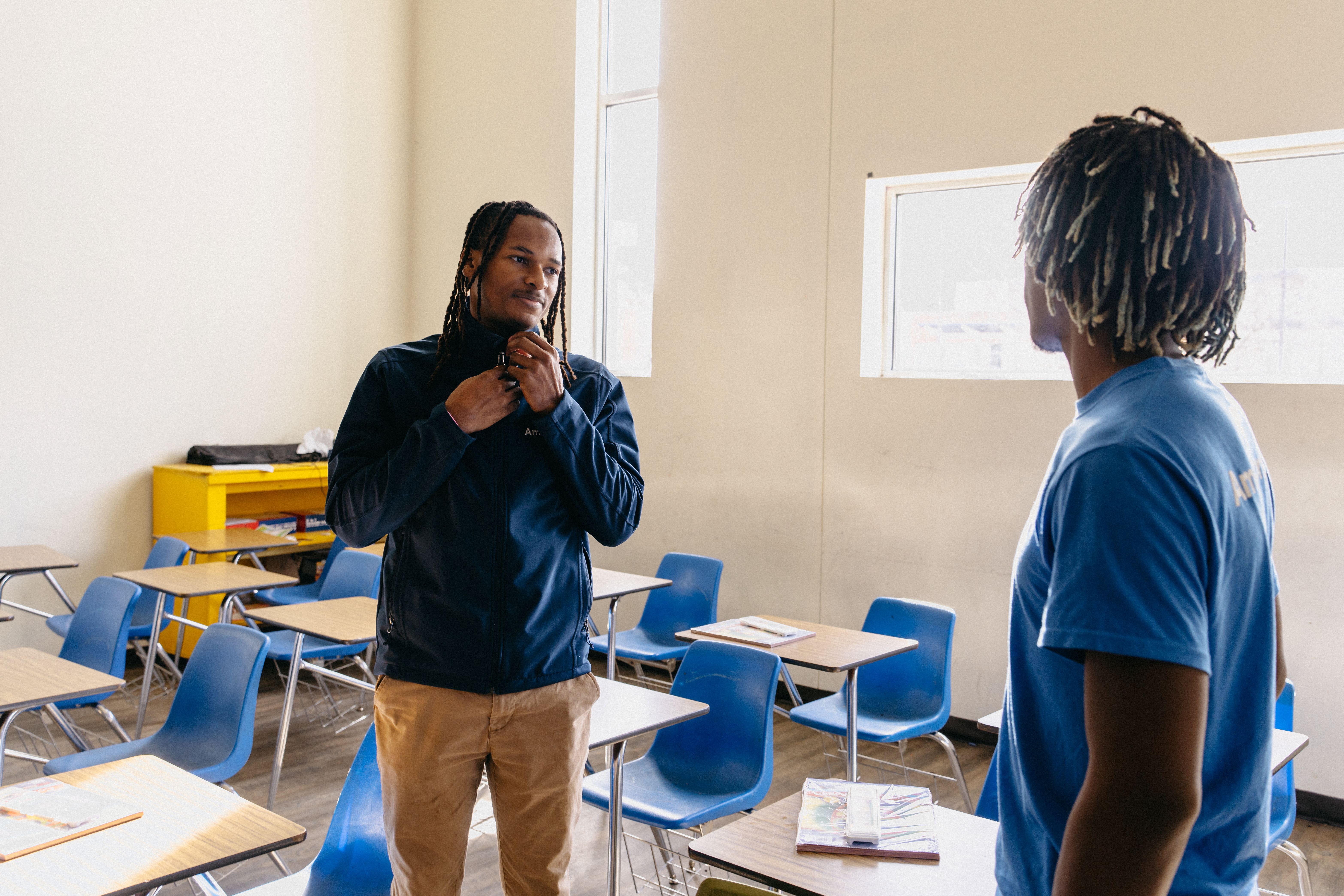 Two AmeriCorps members discuss how best to setup a classroom.