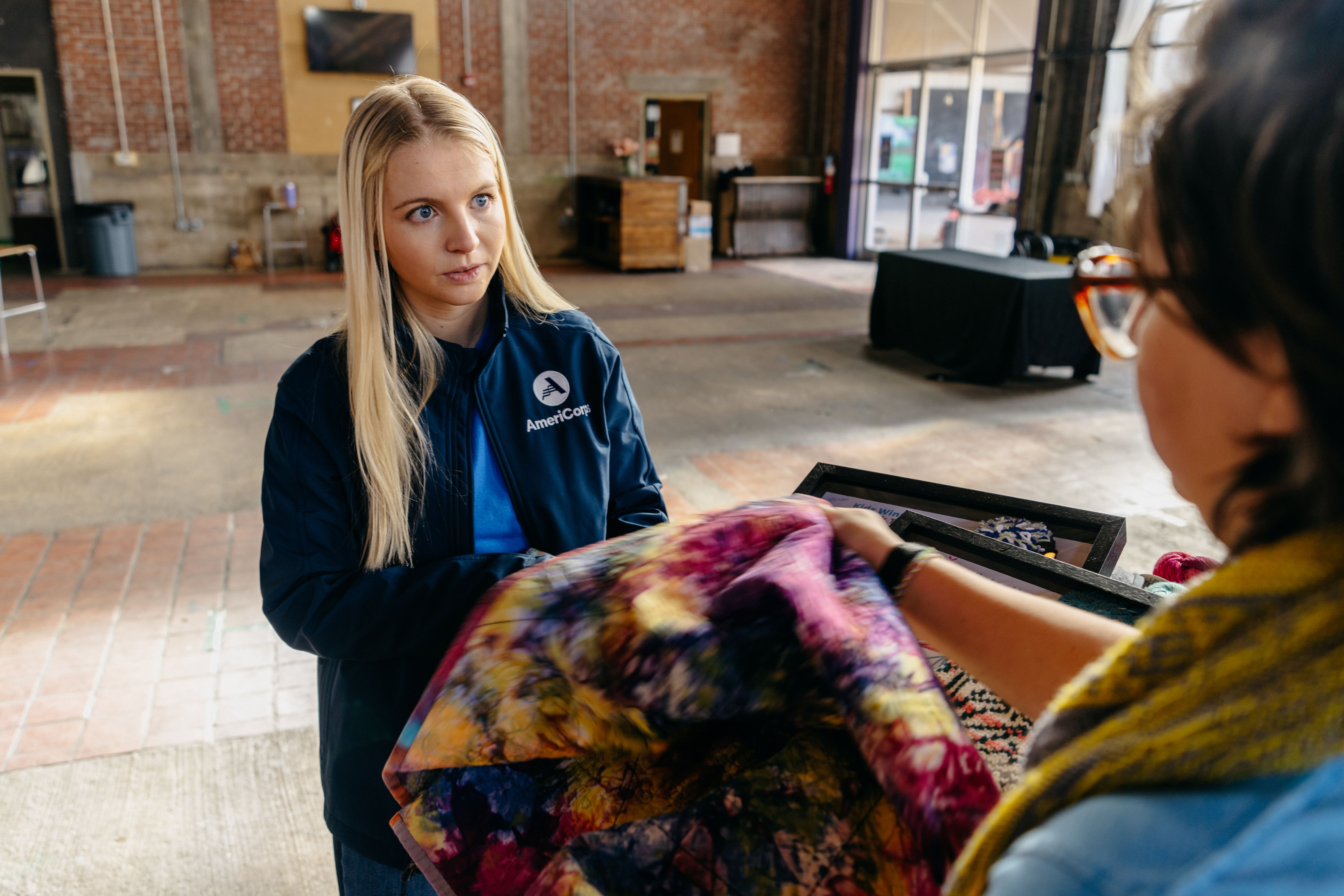 An AmeriCorps member discuss economic opportunities with a community member.