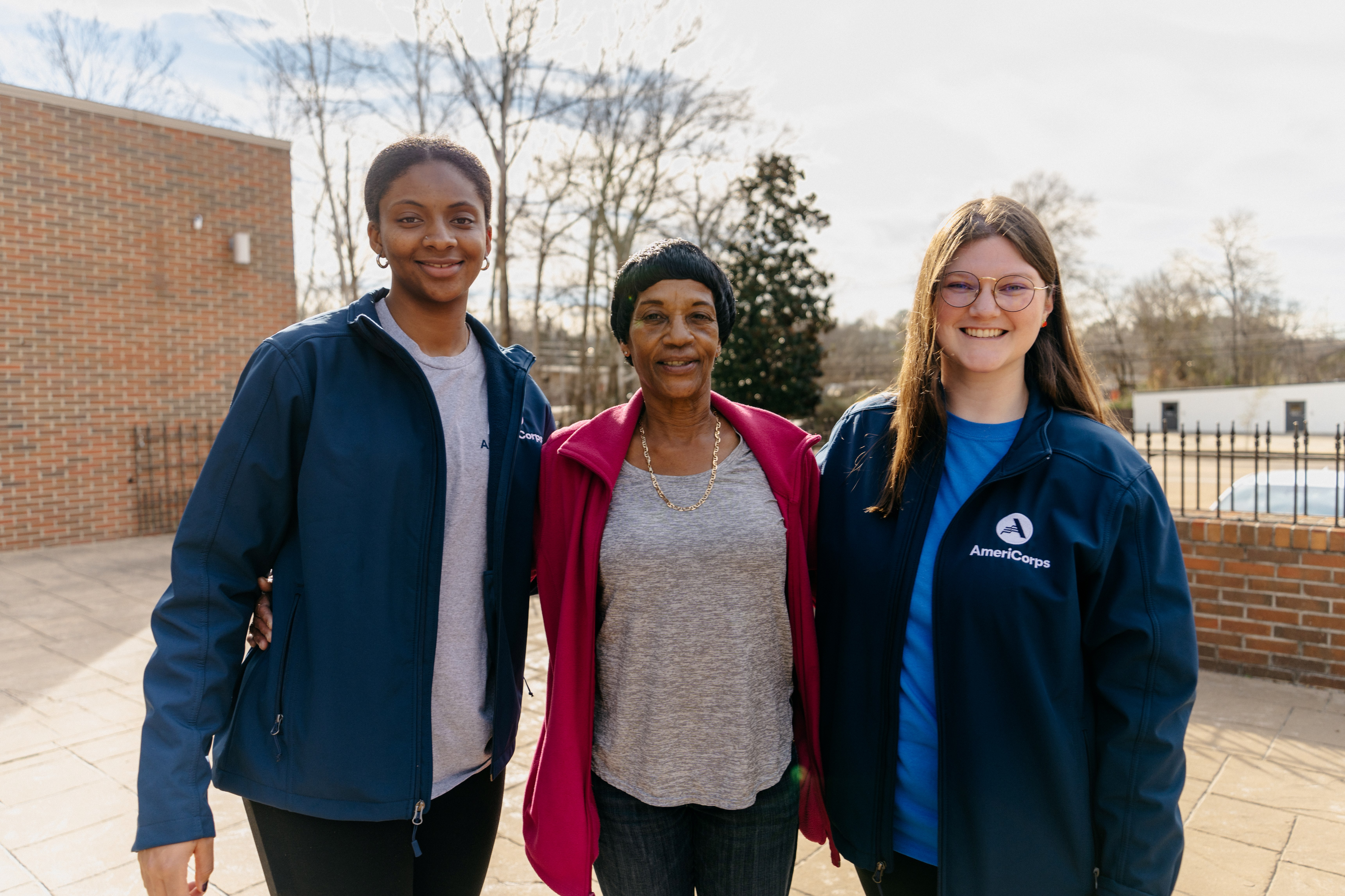 Two AmeriCorps members pose with a community coordinator of the Oxford Community Market at the Oxford Housing Authority.