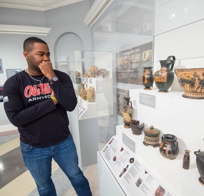 image of a cadet viewing the ancient Greek vases in the UM Museum