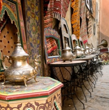 image of a street in Meknes, Morocco with sidewalk tables with tea pots on them