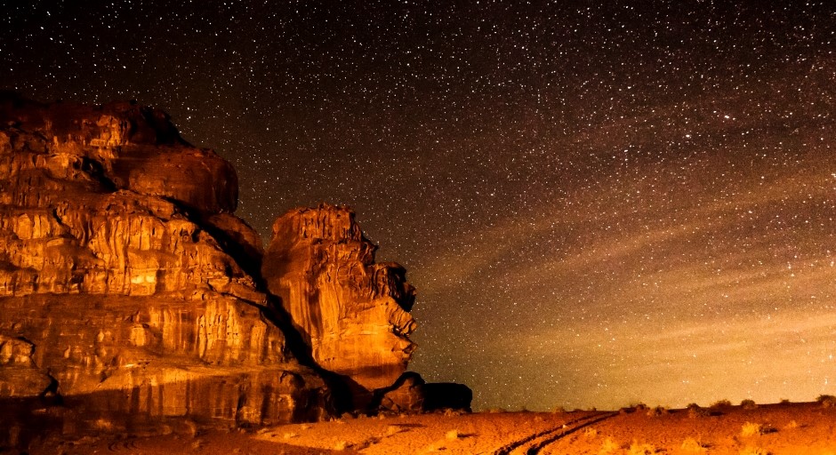 night photo of the mountains in the desert with bright stars