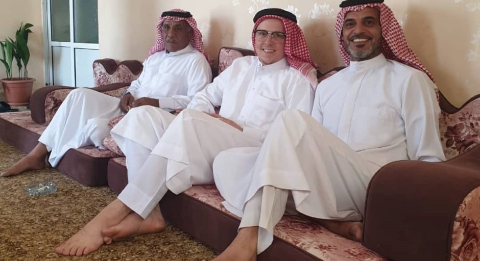 student and two Jordanian men seated in traditional Arab clothing 