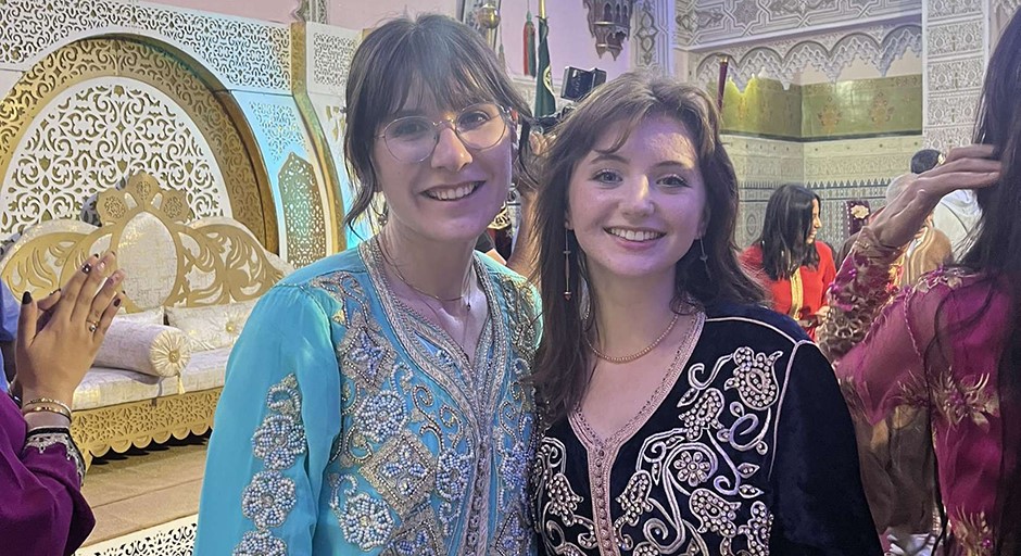 two students posing in traditional Moroccan women's dresses 