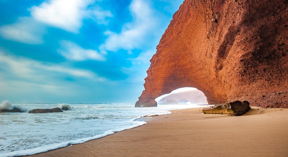 red arches of sandstone along a sea short