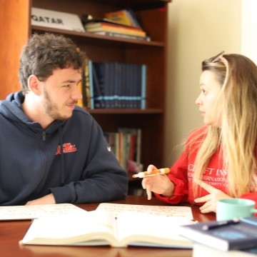 image of a student and staff member seated together studying Arabic 