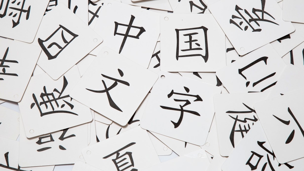 a pile of white cards spread on a table with Chinese characters on each card