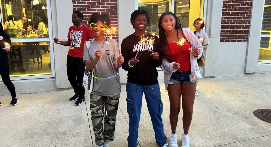 a few students smiling and showing their July 4 sparklers