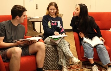 three students seated in the Chinese flagship lounge studying together