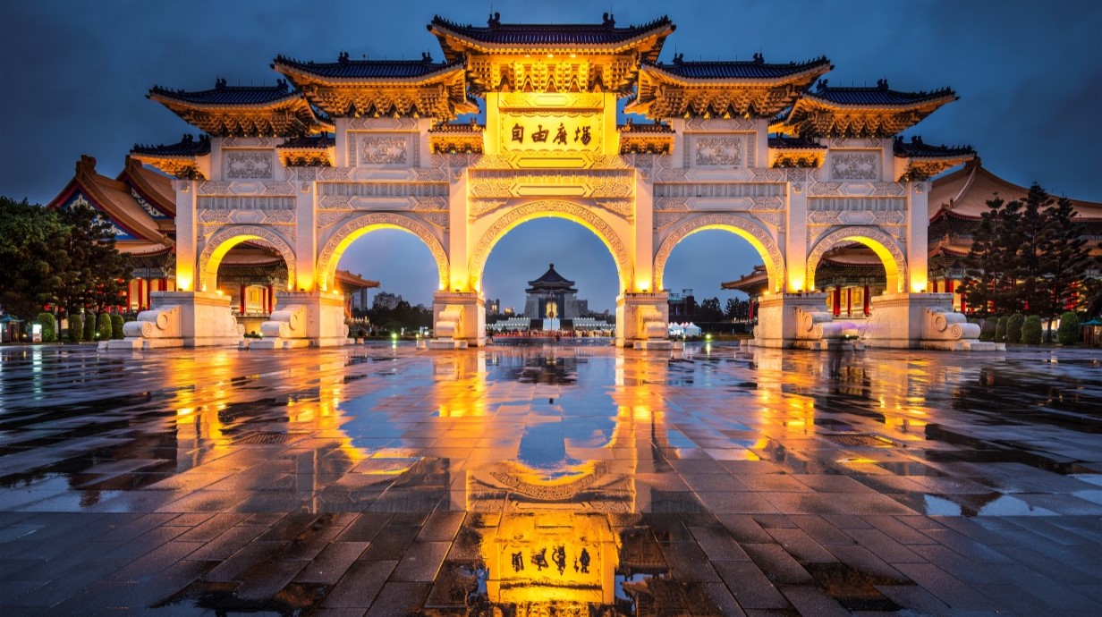 image of a large historic gate and arches lit up at night