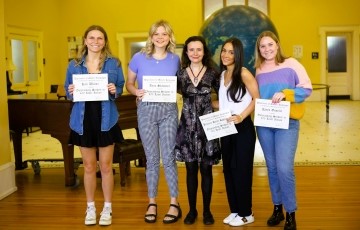 image of a few students holding certificates and smiling at the camera