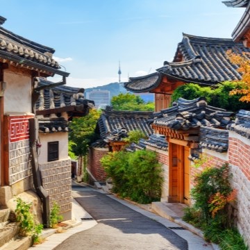 street in Korea with traditional building architecture and a modern skyscraper in the background