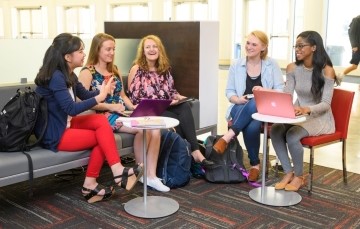 small group of students seated in a lounge and talking together