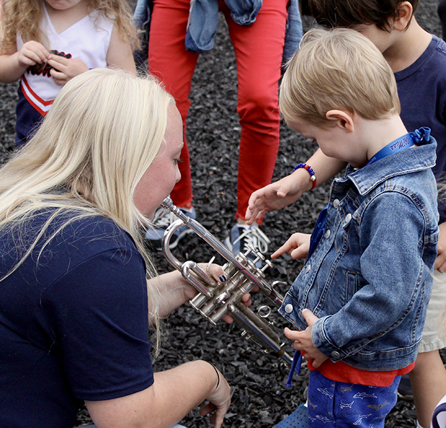 An Ole Miss Band member shows children a trumpet