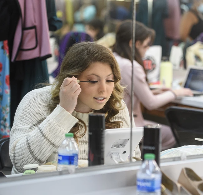 performer applying make up in the dressing room